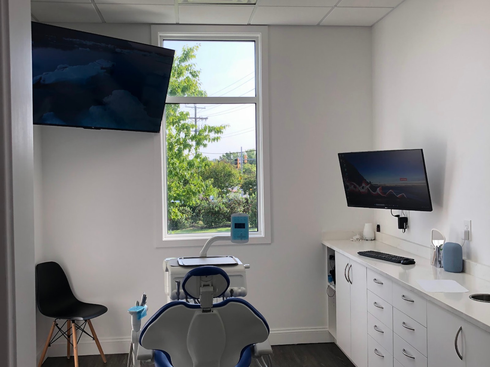 Bright, modern treatment room with chairside monitors and natural light