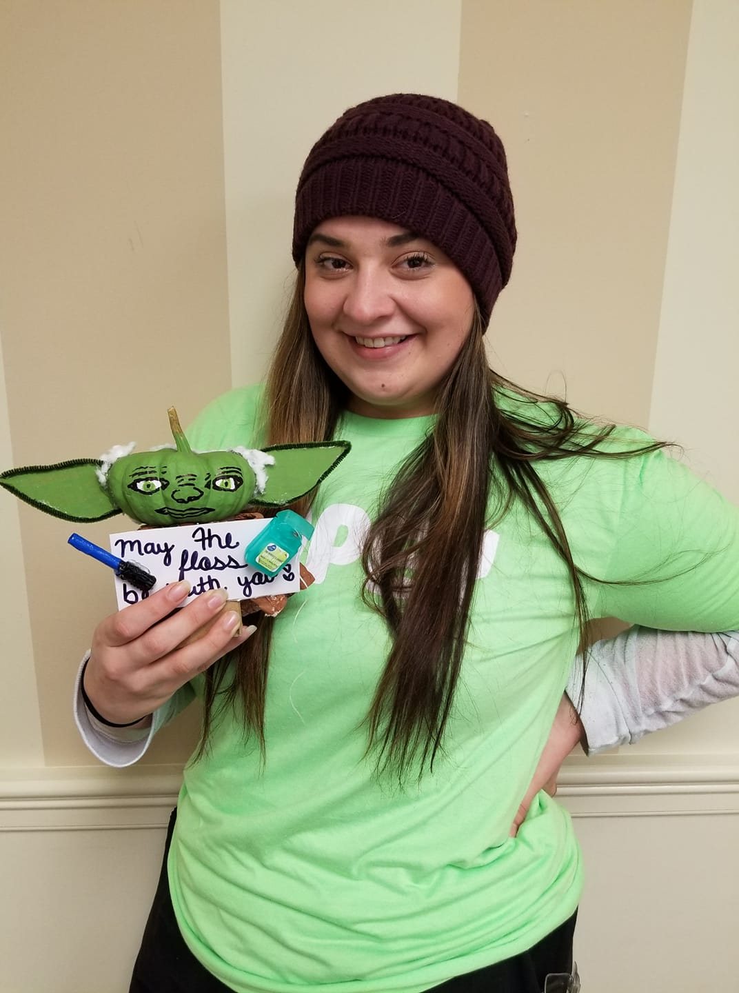 Winner holding a dental-themed pumpkin contest entry