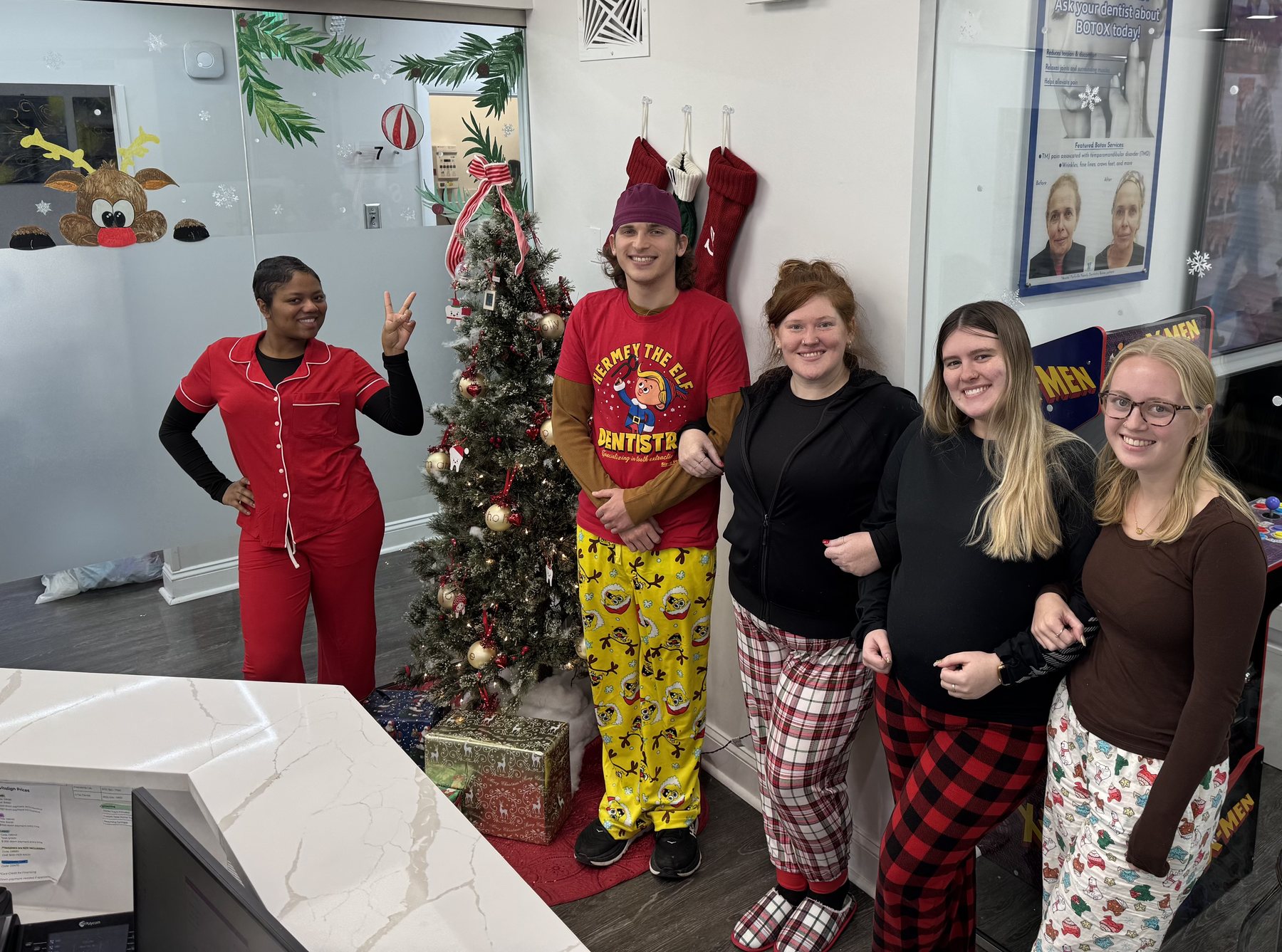 Parkville Family Dentistry team wearing festive pajamas by a Christmas tree