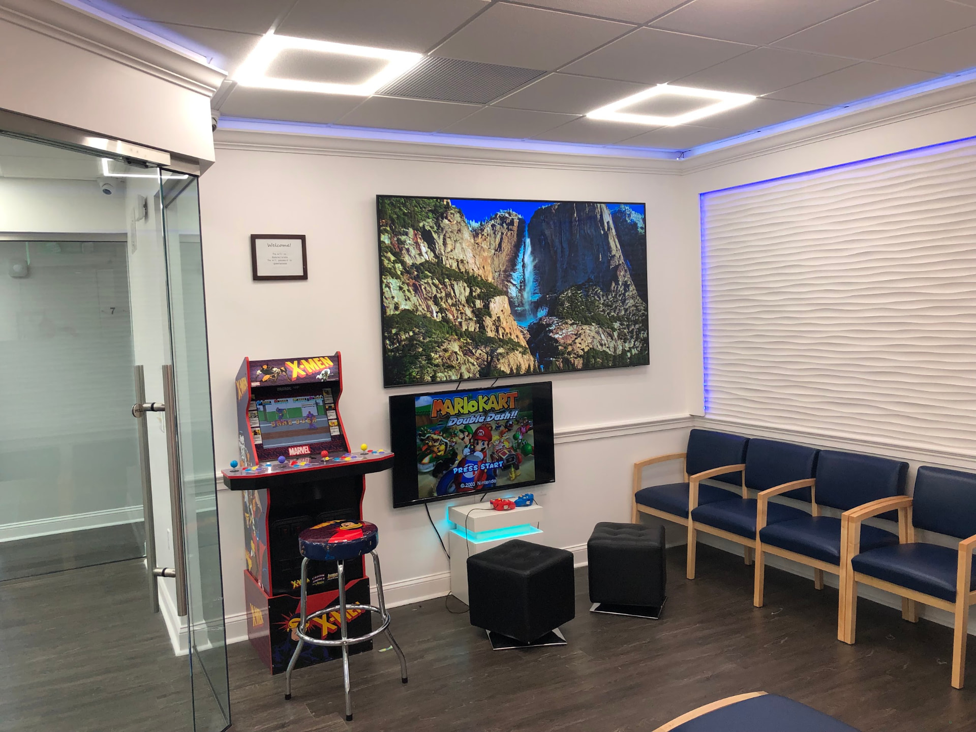 Waiting area with comfortable seating, a large TV and games