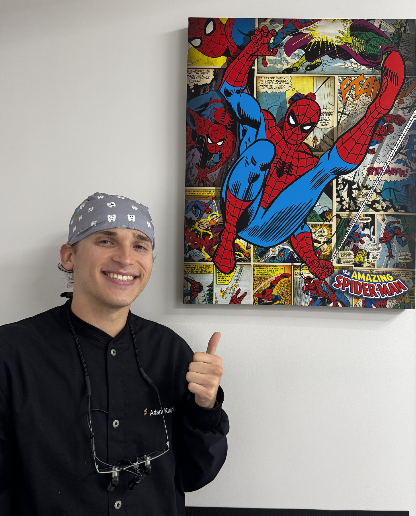 Team member posing beside colorful Spider-Man artwork