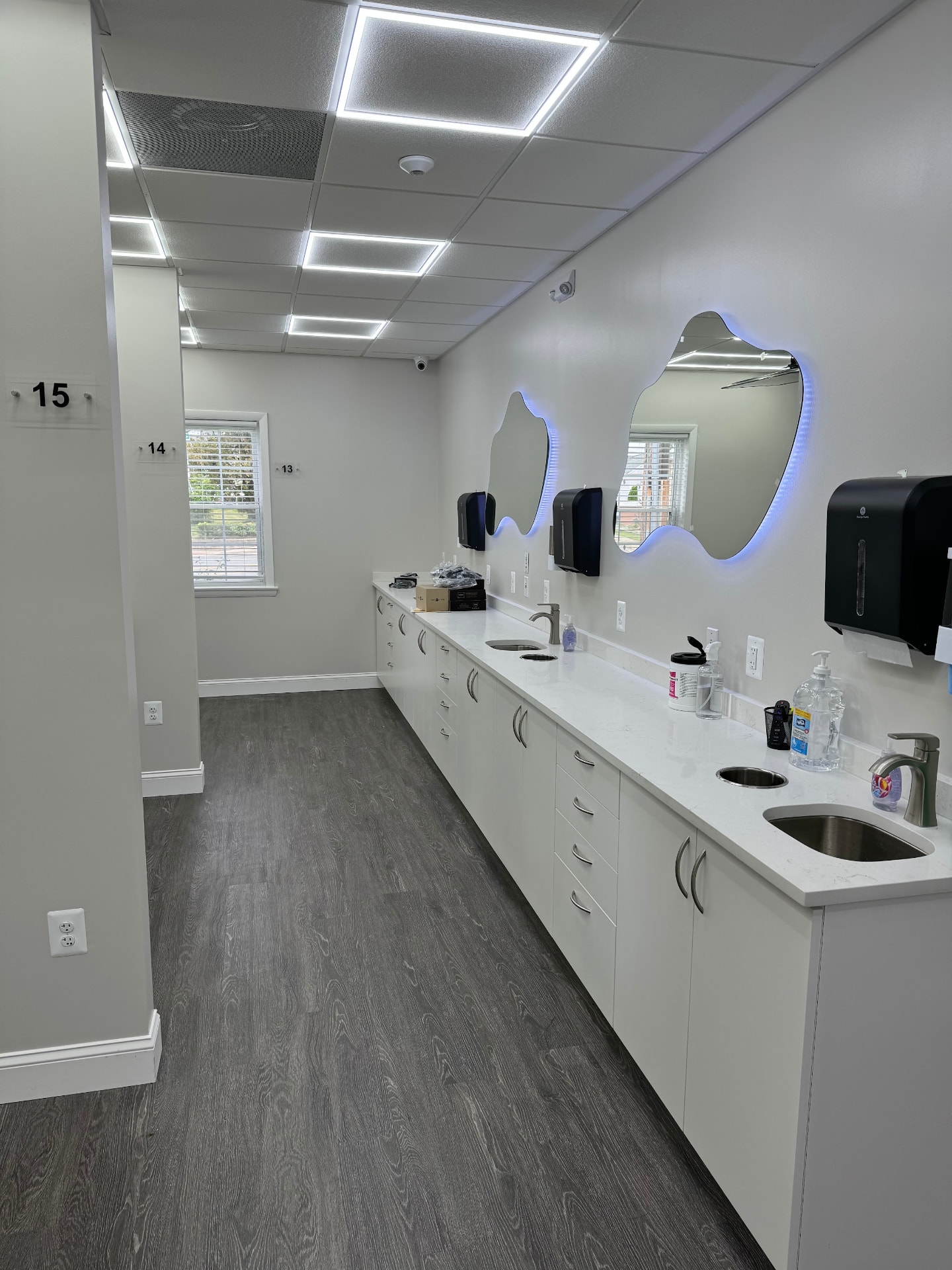 Brushing station with sinks and backlit mirrors
